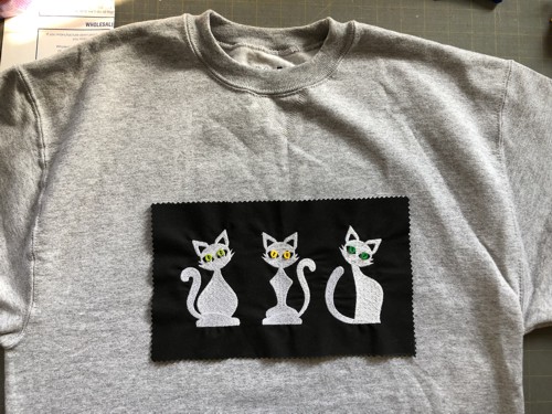 Sew the embroidered patch onto the sweat-shirt.