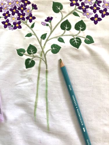 With a green fabric pencil draw the stems of the fowers.