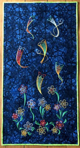 The dark blue wholecloth quilt with flower and butterfly embroidery.