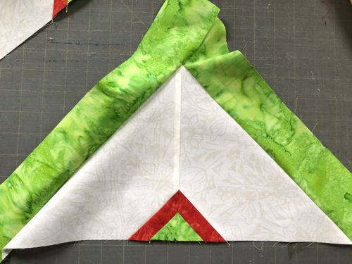 Sew the green strips to the long sides of the triangle.