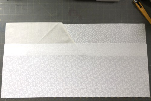 2 strips of white fabric overlapining at long edges