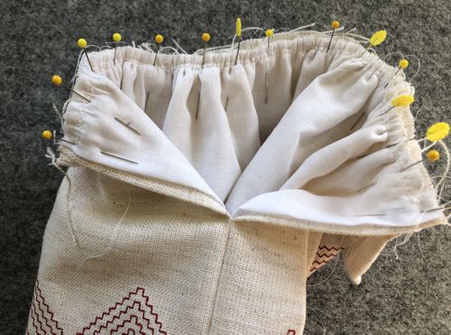 Match the center of the skirt with the center of the bodice front. Pull gathering threads. Pin together.