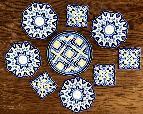 Many stitch-outs of the coasters on a table.