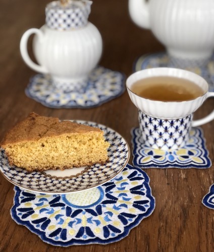 A close-up of the coasters with a plate and a a tea cup.