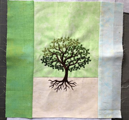 Stitch-out of the summer tree on pale green background.