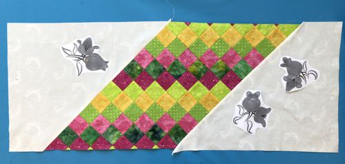 Quilt top with paper print-outs of the embroidery designs