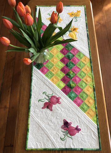 Finished tablerunner on a table with a buquet of flowers