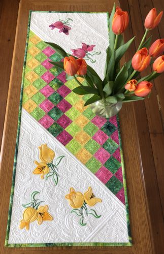 Finished tablerunner on a table with a buquet of flowers