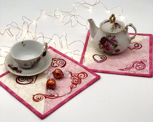 Pink and white mug rugs with heart and swirls embroidery