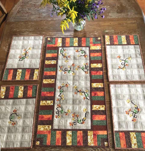 A tablerunner and 4 place mats with fall foliage embroidery.