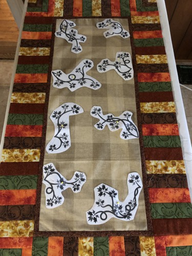 Paper print-out of the designs on the table runner top to mark the position of the embroidery.
