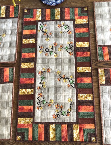 A close-up of the table runner with fall foliage embroidery.