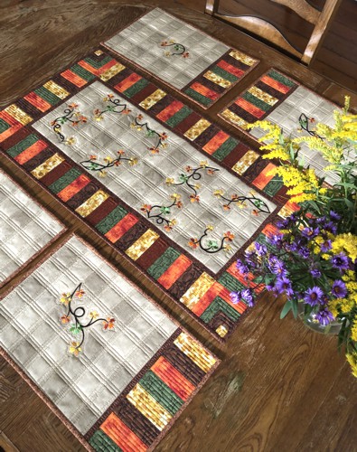 A tablerunner and 4 place mats with fall foliage embroidery.