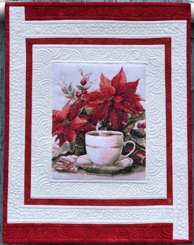 Small red-and-white wall quilt with embroidery of poinsettia and a cup of coffee.