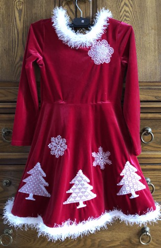 Red child's dress embellished with fir tree and snowflake embroidery.