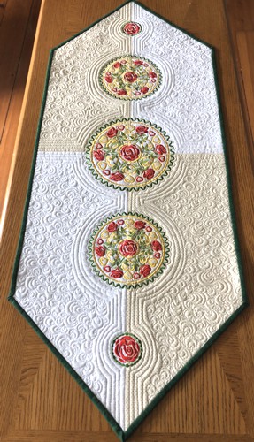Finished tablerunner with rose medallion embroidery on a table
