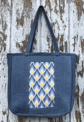 The finished tote bag with decorative embroidery on the front and back panels.