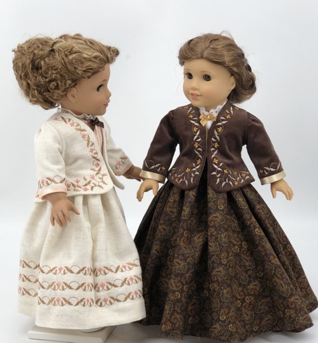 2 dolls in finished historical jackets with embroidery on bodice and sleeves.