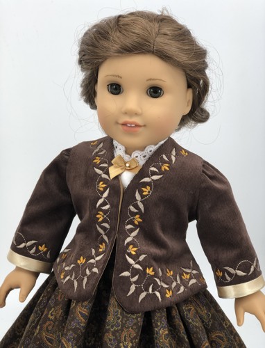 A doll in brown cordiroy jacket with embroidered bodice and sleeves. Front view.