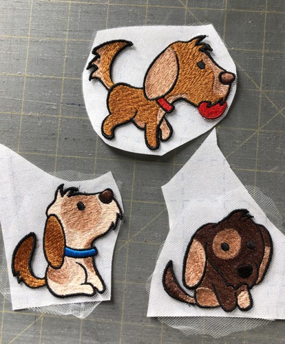 Stitch-outs of the puppies placed onto Steam-A-Seam2 fusible netting