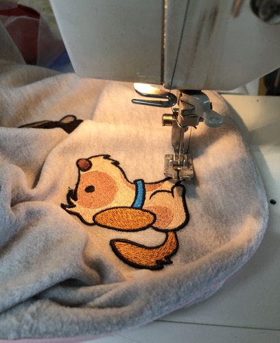 Stitch-out of a puppy sewn onto the sweatshirt