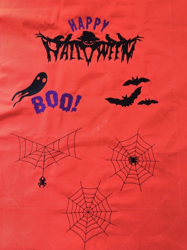 Halloween-themed embroidery is done on the orange fabric