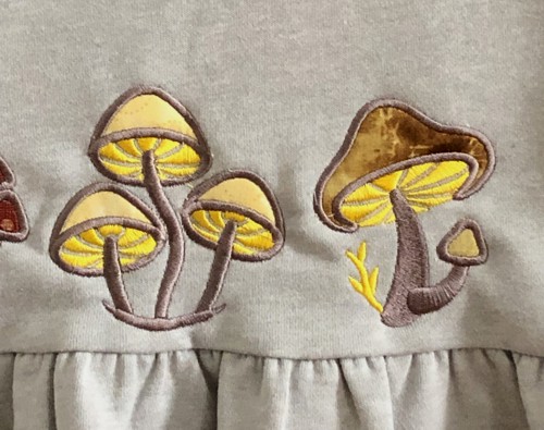 Stitch-outs of 2 applique mushrooms.