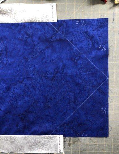 With the quilters ruler and chalk pencil, draw the acute angle on the ends of the tablerunner, but do not cut them now.