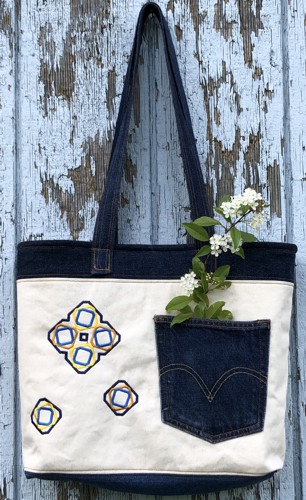 Finished tote bag with embroidery on the front and back panels and quilted lining.