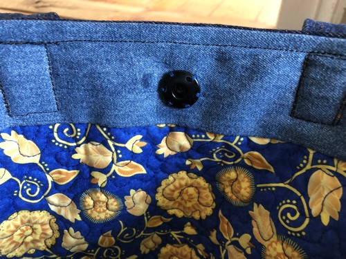 Attach a sew-on snap between the handles.
