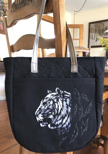 Finished tote bag with embroidery of silver tiger on the front panel.