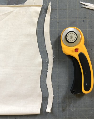 Piece of fabric and a rotary cutter.