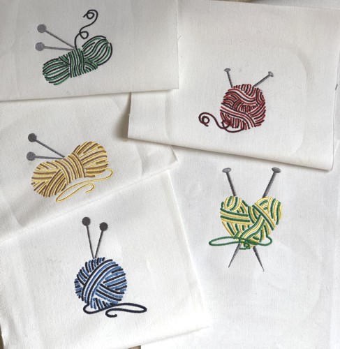 Stitch-outs of the balls of yarn designs on white canvas.