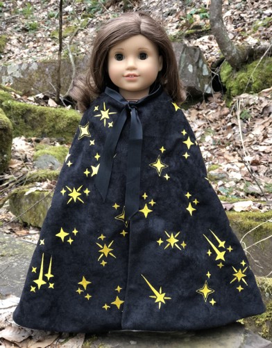 A 18-inch doll in a black cape embroidered with golden stars