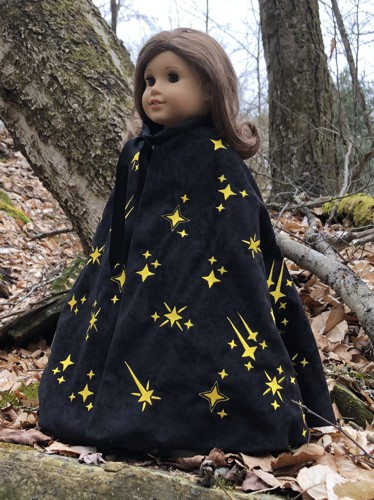 A 18-inch doll in a black cape embroidered with golden stars