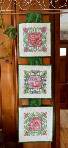 FInished wall-hanging with 3 embroidered and quilted tiles.