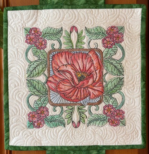 One of the finished tiles with embroidery of a poppy.