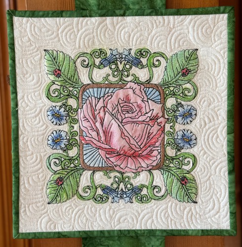 A quilted tile with a rose embroidery