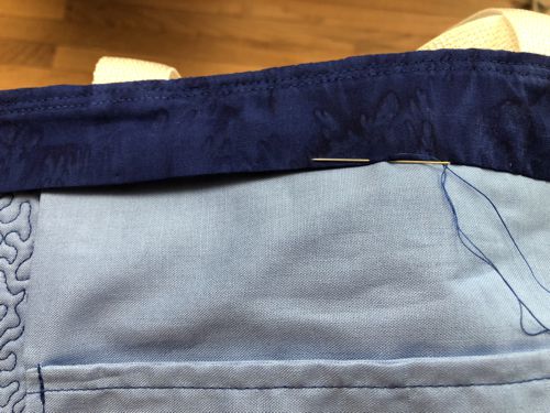 Handstitch the folded edge of the strip to the lining.