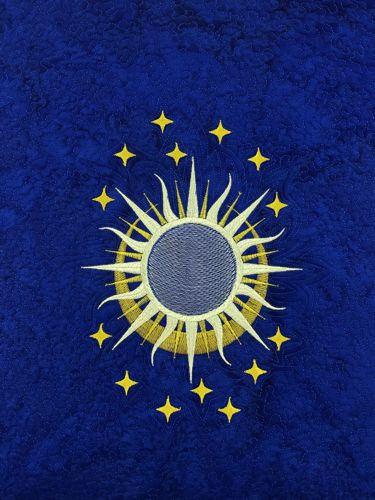 A stitch-out of the Sun and Moon design on the royal blue fabric.