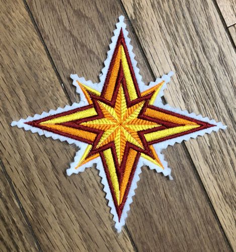 A stitch-out of the star on white felt.