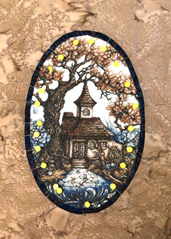 The beige fabric with the oval opening is pinned to the stitch-out.