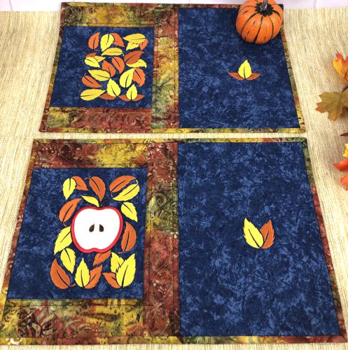Two finished placemats with the autumn-themed embroidery.