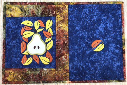 A close-up of a placemat with the pear applique panel.