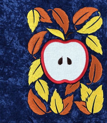 A stitch-out of one of the panels with an apple applique