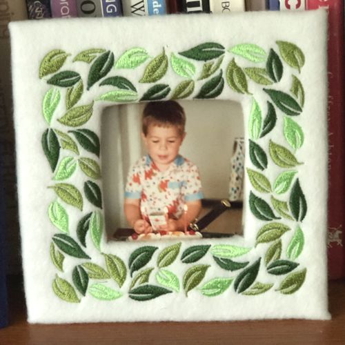 white felt frame with green leaves embroidery.