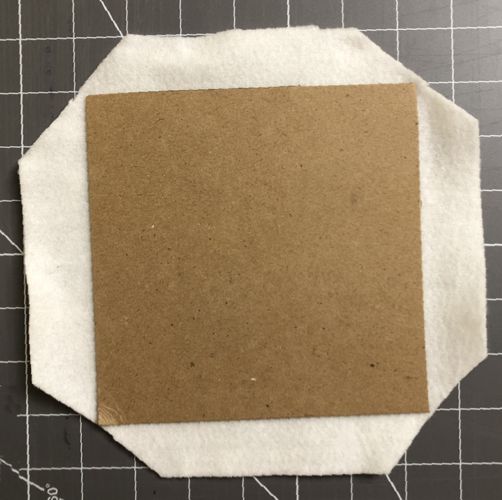 A cardboard square over a piece of felt.