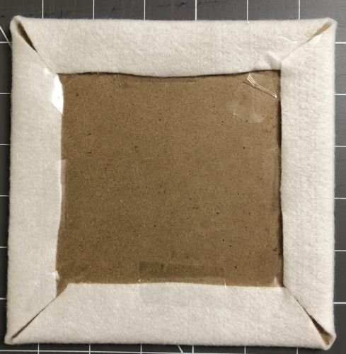 Fold the margins over the carboard and temporary secure with scoth tape. By hand, sew the corners together.