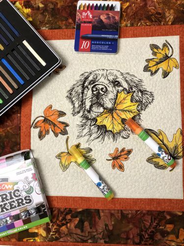 The leaves on the quilt top colored with fabric markers.