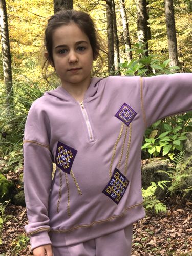 A girl in a lilac sweater with kites applique embroidery